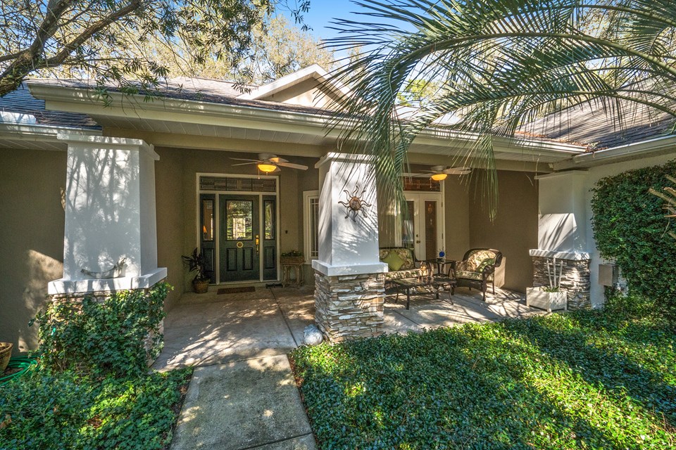 front porch overlooks a professionally landscaped yard and paddocksfam