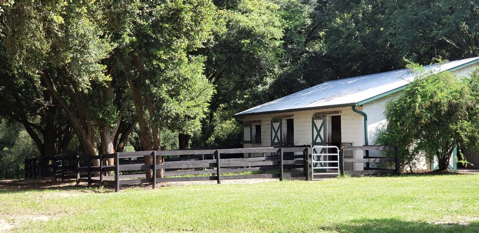 4-stall center aisle block barn with individual runouts, feed & tack rooms & indoor wash area