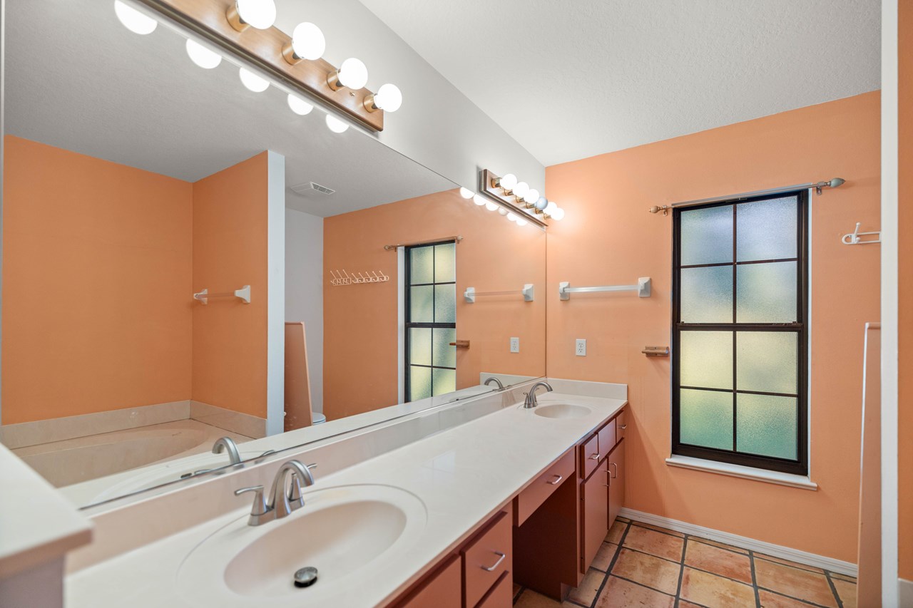 en suite bath has double vanities, garden tub and shower