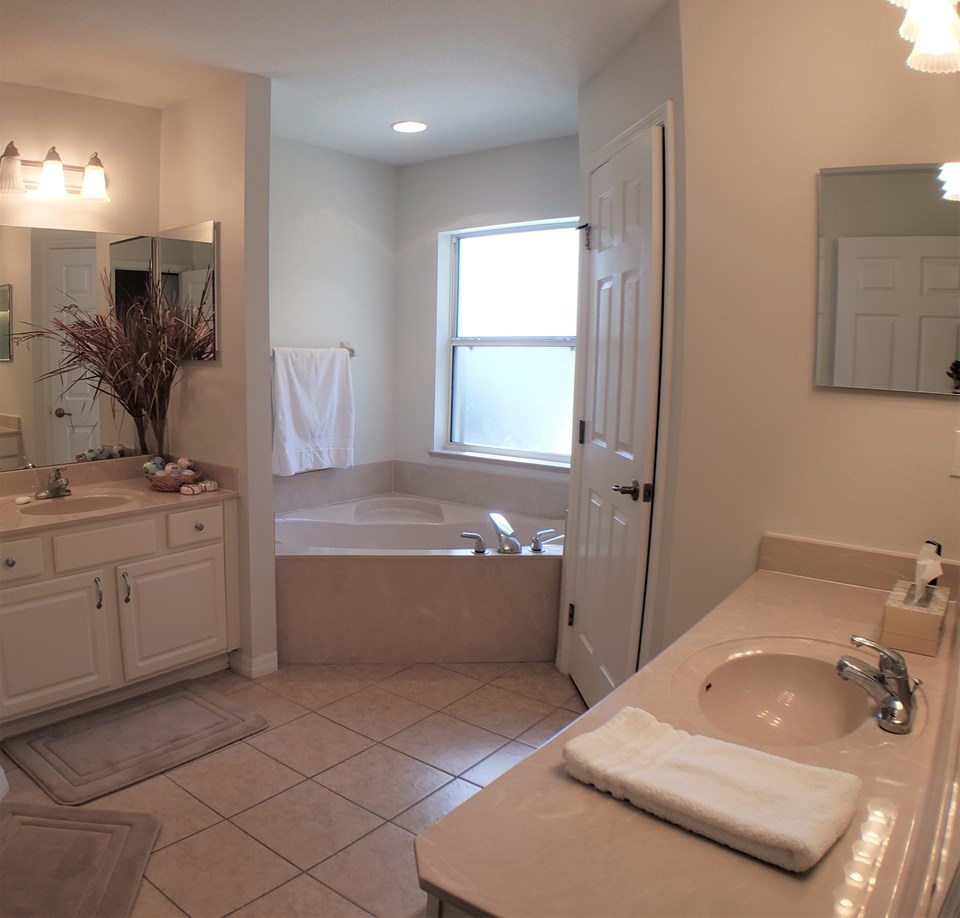 dual vanities with garden tub, walk-in shower and water closet
